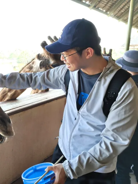 唐岳在觀景台上餵長頸鹿。